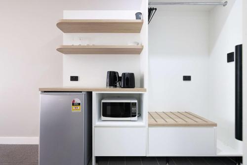 a kitchen with a refrigerator and a microwave at Econo Lodge Gateway Tamworth in Tamworth