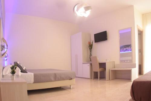 a bedroom with a bed and a desk with a computer at A'MANTIA HOTEL in Amantea
