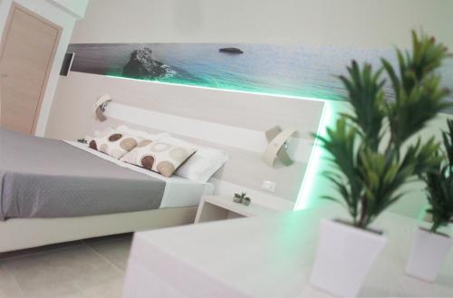 a bedroom with a bed and a painting of the ocean at A'MANTIA HOTEL in Amantea