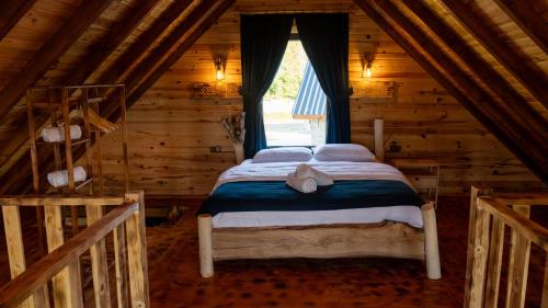 a bed in a log cabin with a window at Şahmaran Bungalov in Ardeşen