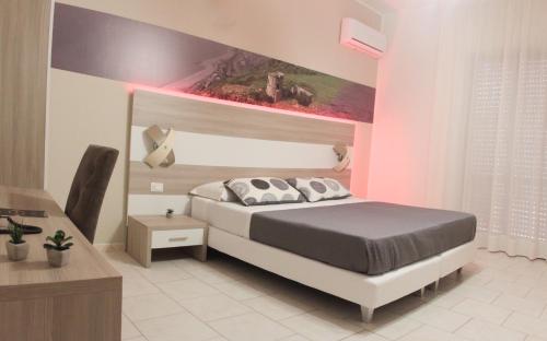 a bedroom with a bed and a pink wall at A'MANTIA HOTEL in Amantea