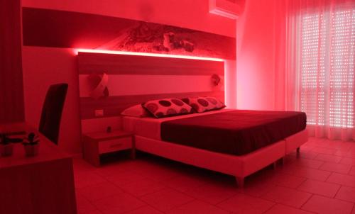 a red bedroom with a bed with a red light at A'MANTIA HOTEL in Amantea