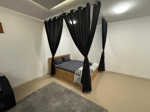 a bedroom with a bed with black curtains at Apartamenty na Górce in Olsztyn
