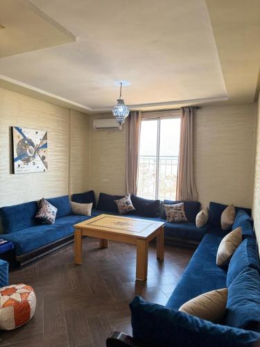 a living room with a blue couch and a table at Ouzoud le Panorama in Ouzoud
