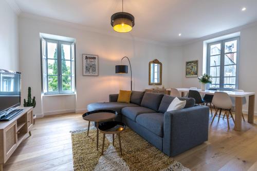 un salon avec un canapé bleu et une table dans l'établissement Appartement intramuros hyper centre Avignon, à Avignon