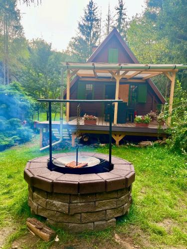 a house with a fire pit in front of it at Kerekerdő Apartman - Szarvaskő in Szarvaskő