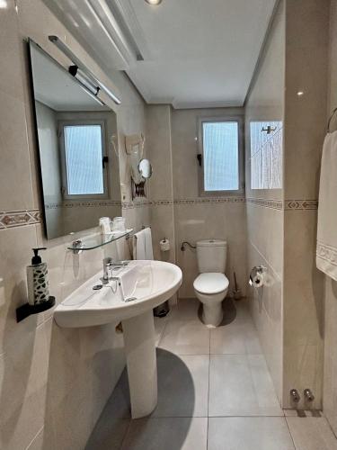 a bathroom with a sink and a toilet and a mirror at Hotel Costasol in Almería