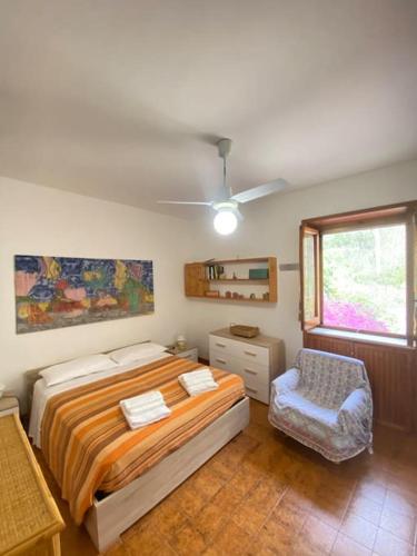 a bedroom with a bed and a chair and a window at Casa del Fico in Santa Caterina di Nardò