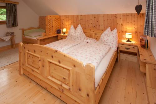 DeutschgriffenにあるKinderbauernhof Anderleのウッドフロアの客室で、大型の木製ベッド1台が備わります。