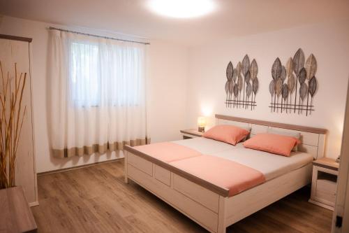 a bedroom with a bed with orange pillows and a window at La Bora in Izola