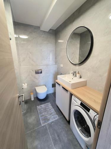 a bathroom with a washing machine and a sink at Apartments Silvana in Sveta Nedelja