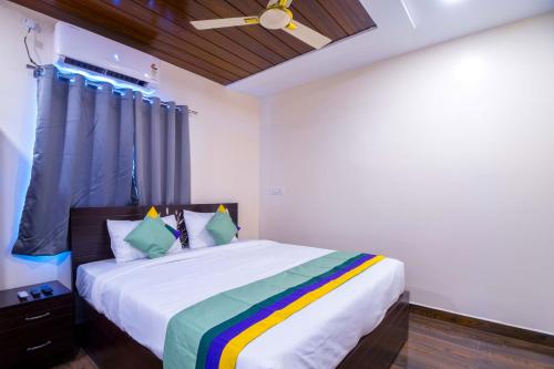 a bedroom with a large bed with a colorful blanket at Treebo The Address Inn Mehdipatnam in Hyderabad