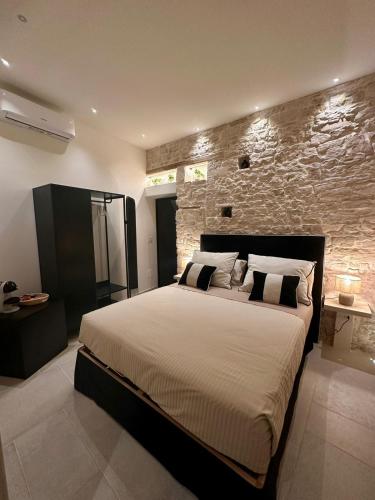 a bedroom with a large bed with a stone wall at DIMORA BELLAVISTA in Bitonto