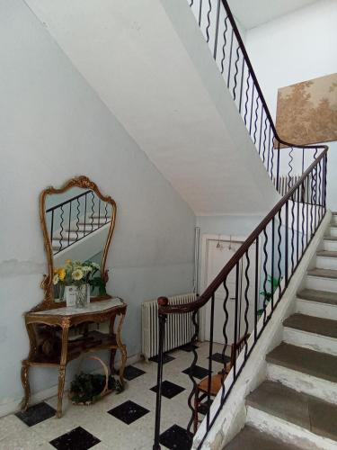 a staircase with a mirror and a table in a room at Occ34 - Capestang - Manoir in Capestang