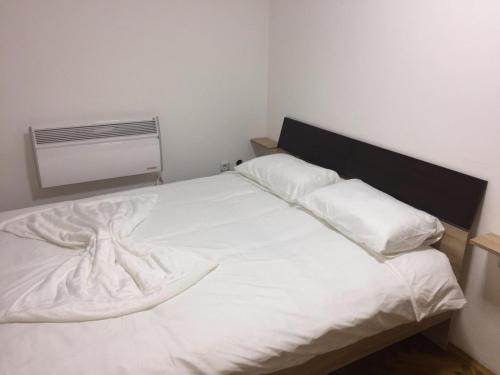 Una cama blanca con dos almohadas encima. en Kod Bolnice, en Novi Pazar