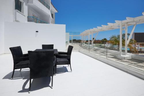 a patio with black chairs and a table on a building at Golden Palace Marina Hotel in El Alamein