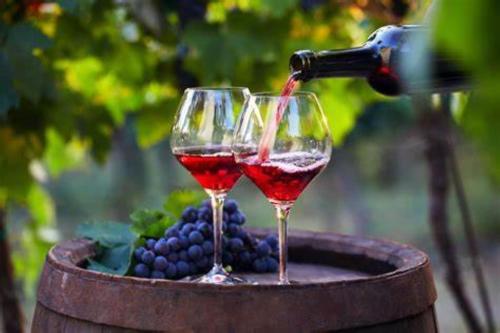 two wine glasses are being filled with red wine at Occ34 - Capestang - Manoir in Capestang
