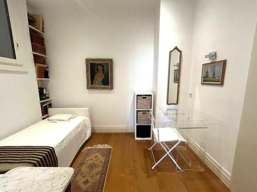 Cette petite chambre comprend un lit et une table en verre. dans l'établissement Superbe appartement de 100m2 face à la mer Dans un ancien palace, à Menton