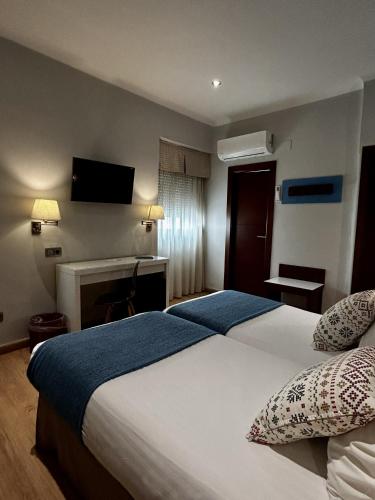 a hotel room with a large bed and a television at Hotel Costasol in Almería