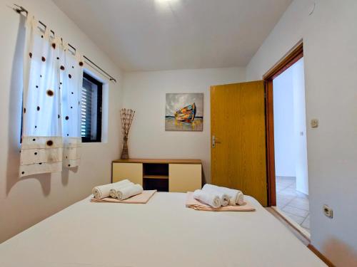 a bedroom with a bed with two pillows on it at Robinson Edita in Bogomolje