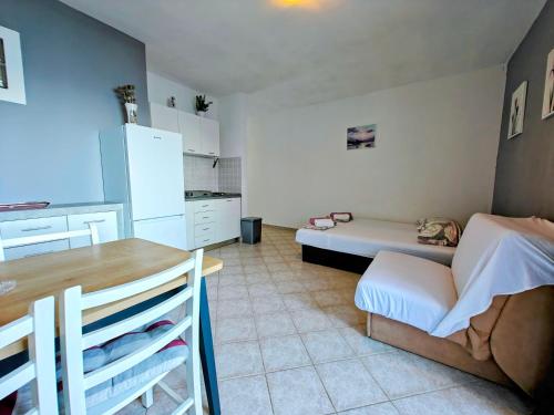 a kitchen with a couch and a table in a room at Robinson Edita in Bogomolje