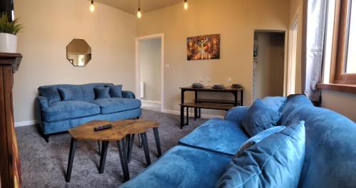a living room with a blue couch and a table at 3DB, 4 Rooms, Sleeps 8, Swansea, Smart Tv's In Every Room in Port Talbot