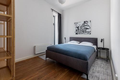 a bedroom with a bed with a blue blanket at K1820 Family apartments in Rīga