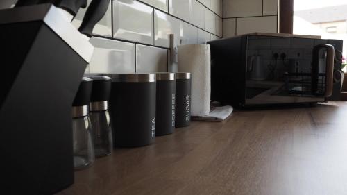 a row of coffee cups sitting on a kitchen counter at 3DB, 4 Rooms, Sleeps 8, Swansea, Smart Tv's In Every Room in Port Talbot