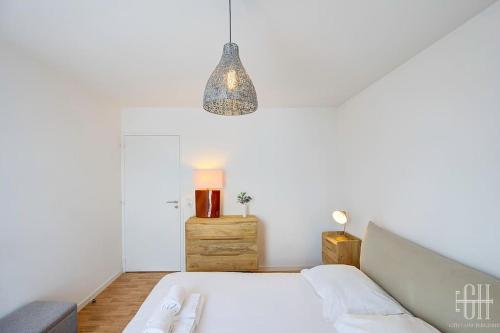 - une chambre avec un lit et une lampe pendant dans l'établissement Le Lilas - 2 chambres - parking, à Tours