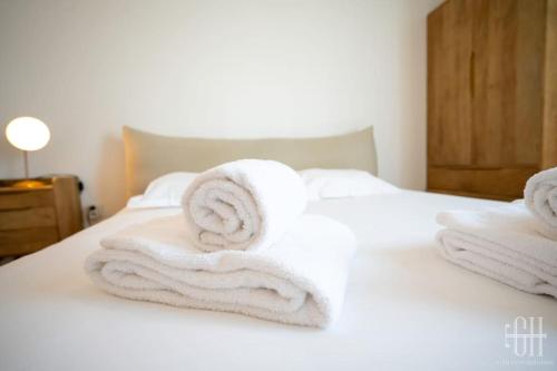 une pile de serviettes posée sur un lit dans l'établissement Le Lilas - 2 chambres - parking, à Tours