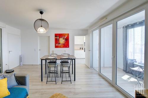 d'une salle à manger avec une table et des chaises dans le salon. dans l'établissement Le Lilas - 2 chambres - parking, à Tours