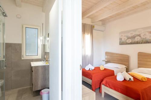 1 dormitorio con 2 camas y baño con lavamanos en Casa Vacanze Gioberta, en Menfi