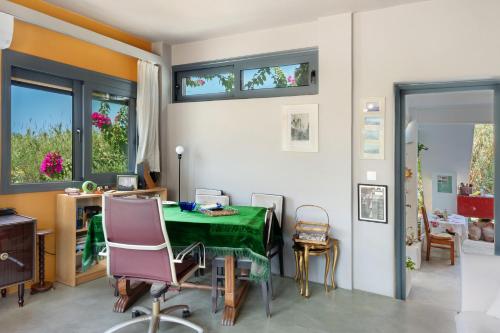 una sala da pranzo con tavolo e sedie verdi di Livadi House Amorgos ad Aegiali