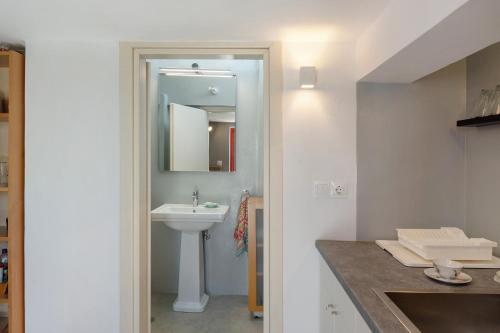 un bagno bianco con lavandino e specchio di Livadi House Amorgos ad Aegiali