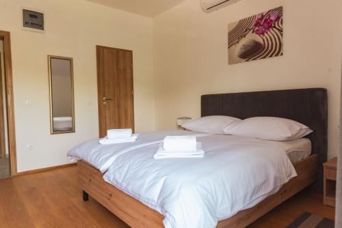 a bedroom with a bed with two white towels on it at Rooms Enter Ogulin in Oštarije