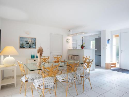 une cuisine et une salle à manger avec une table et des chaises en verre dans l'établissement Holiday Home Eden Club by Interhome, à Lacanau-Océan