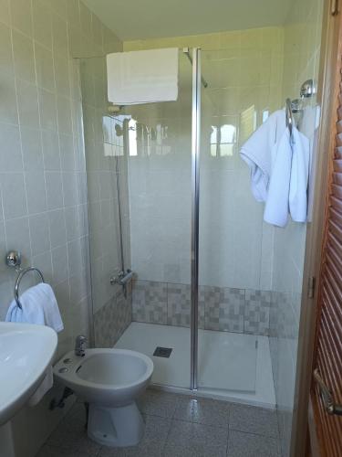 a bathroom with a shower and a toilet and a sink at Hotel Santa María in Palos de la Frontera