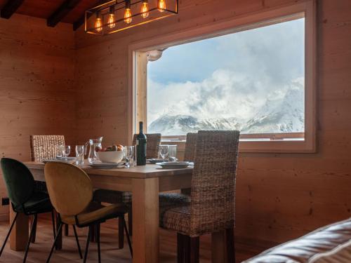ein Esszimmer mit einem Tisch und einem großen Fenster in der Unterkunft Chalet Le Loup- le Renard et la Belette by Interhome in Nendaz