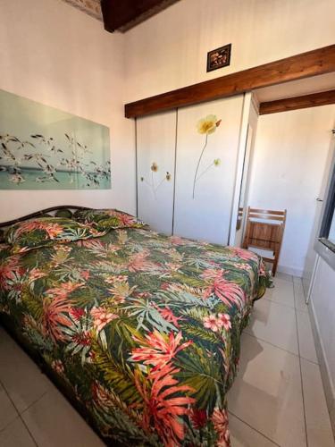 une chambre avec un lit avec un couvre-lit fleuri dans l'établissement Aquaplage Cap d Agde, au Cap d'Agde