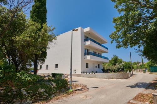 a white building on the side of a road at Urban Apartment Endji in Močići