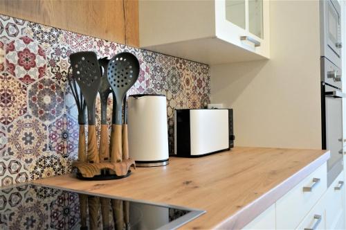 a kitchen counter with utensils on a shelf at Mein Apartment Flowers mit Kamin, bis 10 Personen in Frankenthal