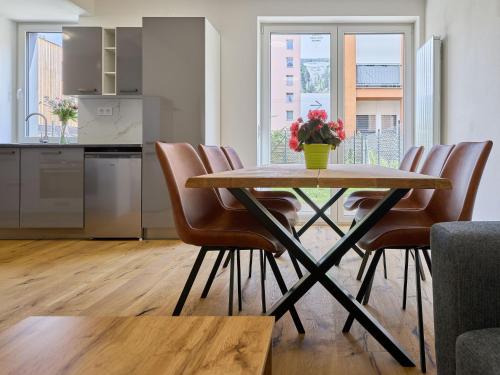 a dining room table with chairs and a vase of flowers at Apartment Trendy Mountain Terrace Retreat by Interhome in Svoboda nad Úpou
