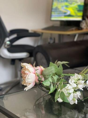a vase of flowers sitting on a glass table at Private apt close to train station in London