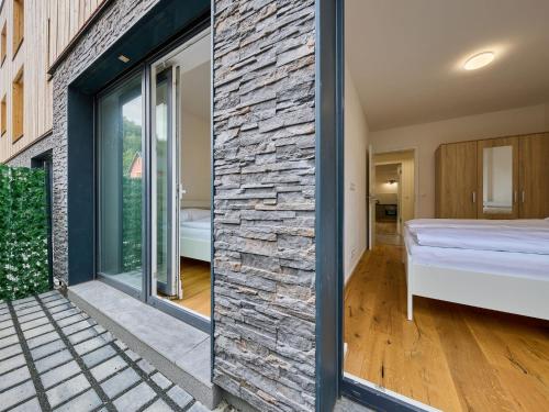 スヴォボダ・ナト・ウーポウにあるApartment Modern Mountain Terrace Retreat & Pets by Interhomeの石壁の客室とベッドルーム1室が備わります。