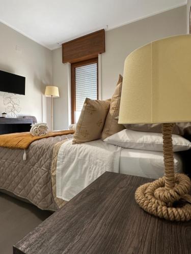 a bedroom with a bed with a lamp on a table at Agorà Connect Space in Brindisi
