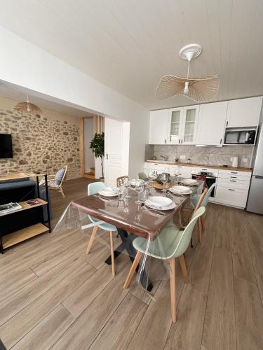 une cuisine et une salle à manger avec une table et des chaises dans l'établissement Ô Lavoir, aux Épesses
