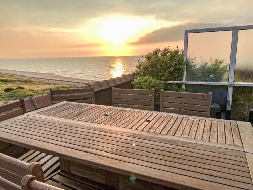 d'une table et de chaises en bois sur un balcon donnant sur l'océan. dans l'établissement Apartment Horizon Marin-8 by Interhome, à Cabourg