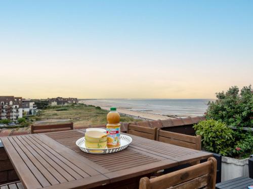 une table en bois avec deux tasses de café au sommet d'un balcon dans l'établissement Apartment Horizon Marin-8 by Interhome, à Cabourg