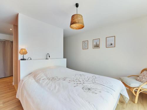 a white bedroom with a bed and a chair at Holiday Home Denneweiller by Interhome in Denneville