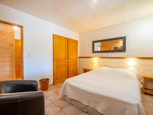 une chambre avec un lit, une chaise et un miroir dans l'établissement Apartment Villa Maeva by Interhome, à Cavalaire-sur-Mer